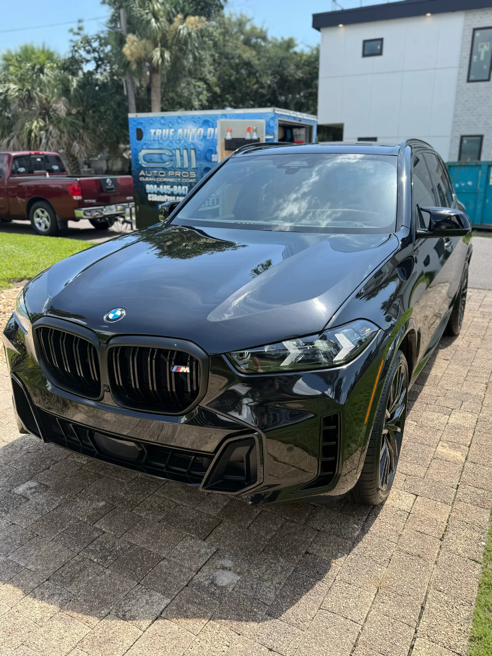 Mobile auto detailing Jacksonville FL - BMW in owner's driveway after professional detailing with C3 Auto Pros truck